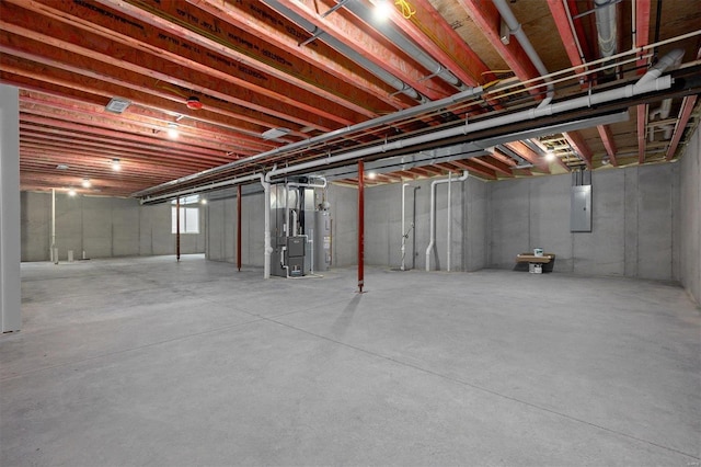 basement featuring electric panel, water heater, and heating unit