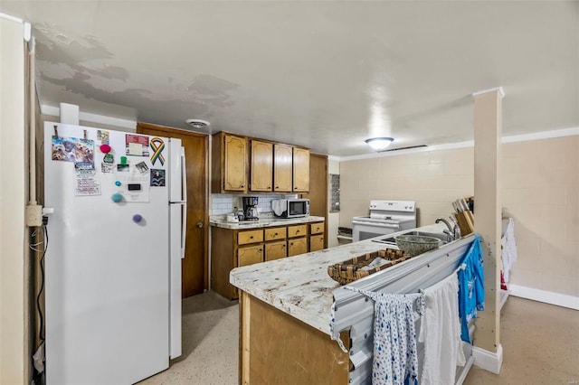 kitchen with tasteful backsplash, white appliances, and sink