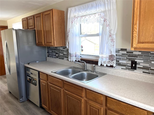 kitchen featuring appliances with stainless steel finishes, dark hardwood / wood-style flooring, backsplash, and sink