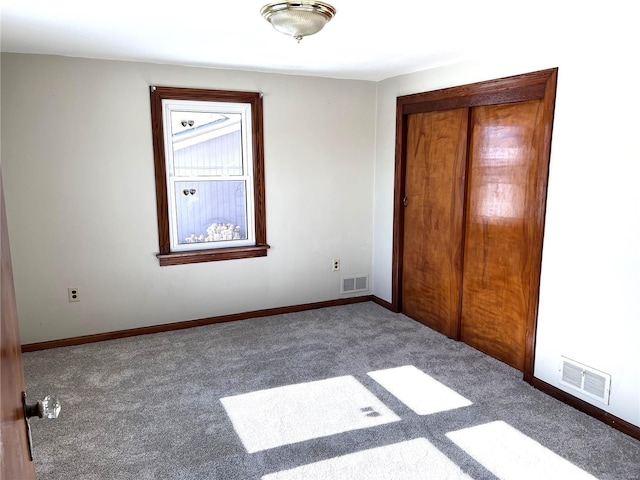 unfurnished bedroom with a closet and dark colored carpet