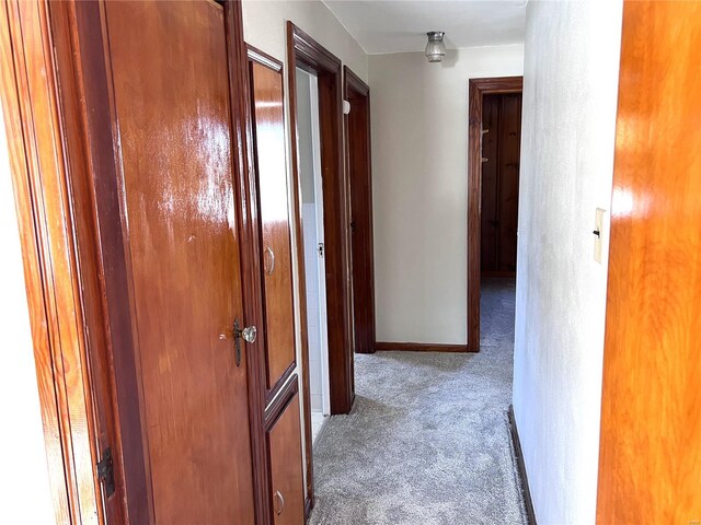 hallway featuring dark colored carpet