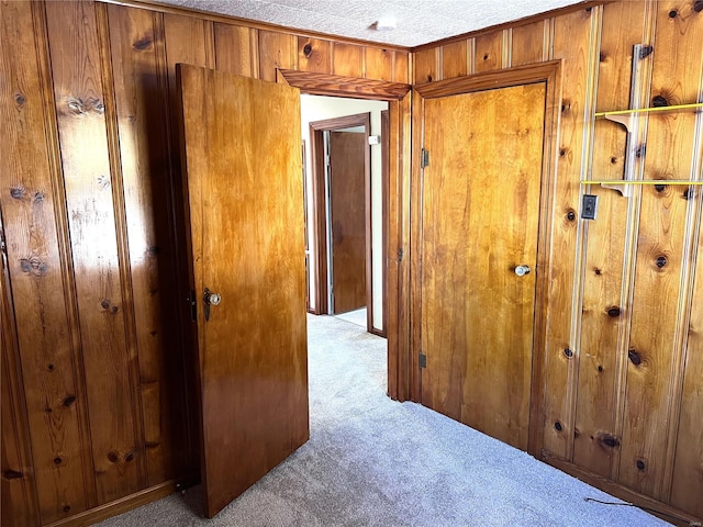 interior space featuring light carpet and wood walls