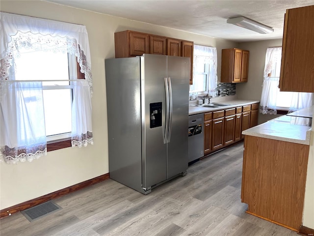 kitchen with light hardwood / wood-style floors, appliances with stainless steel finishes, and sink