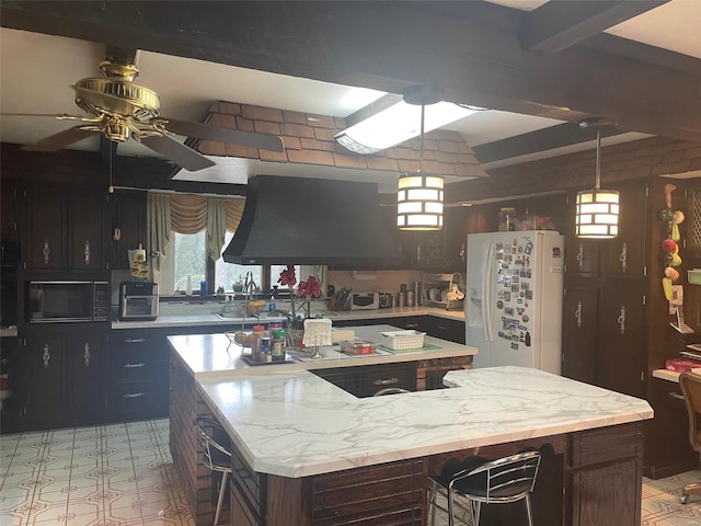 kitchen featuring beam ceiling, ceiling fan, white fridge with ice dispenser, hanging light fixtures, and island exhaust hood