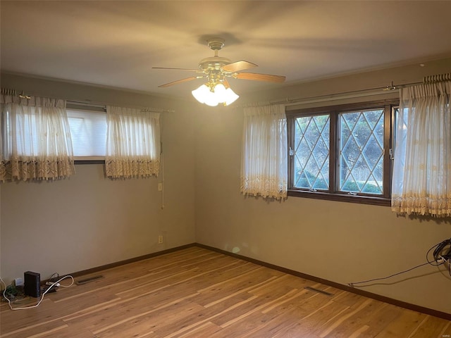 unfurnished room with ceiling fan, a wealth of natural light, and hardwood / wood-style floors