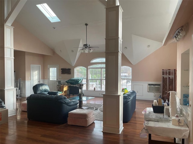 living room with ornate columns, high vaulted ceiling, a skylight, dark hardwood / wood-style floors, and ceiling fan