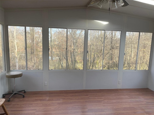 unfurnished sunroom featuring ceiling fan, a wealth of natural light, and vaulted ceiling