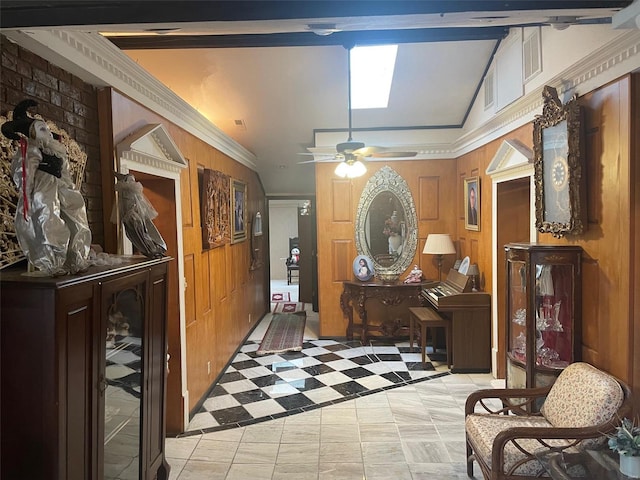 tiled entrance foyer featuring ceiling fan, wooden walls, ornamental molding, and vaulted ceiling