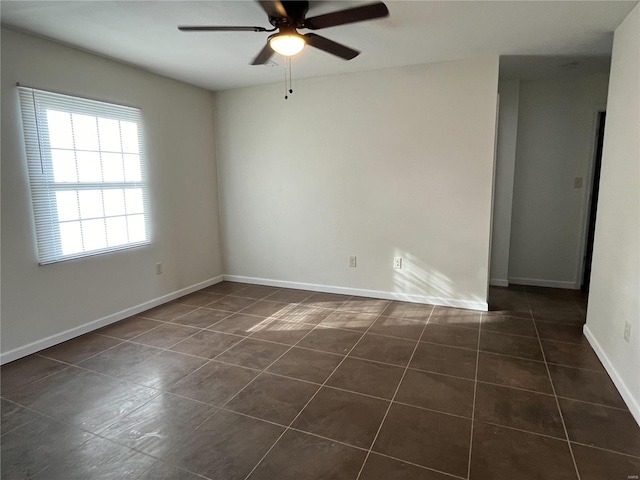 tiled spare room with ceiling fan