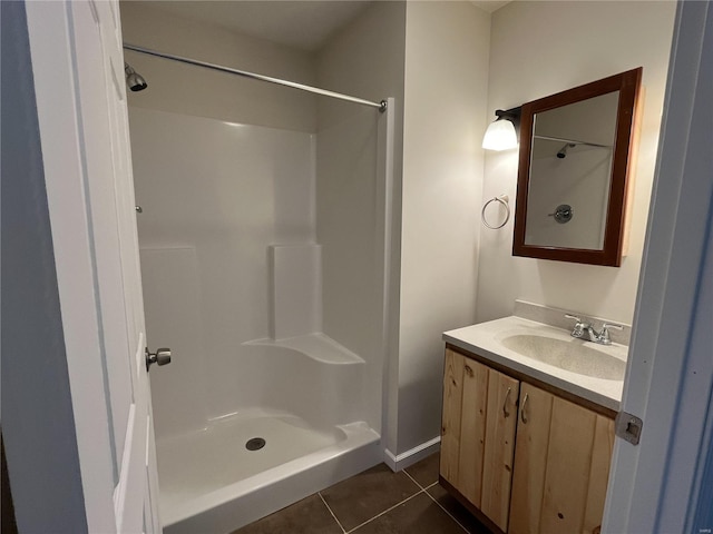 bathroom featuring a shower, vanity, and tile flooring