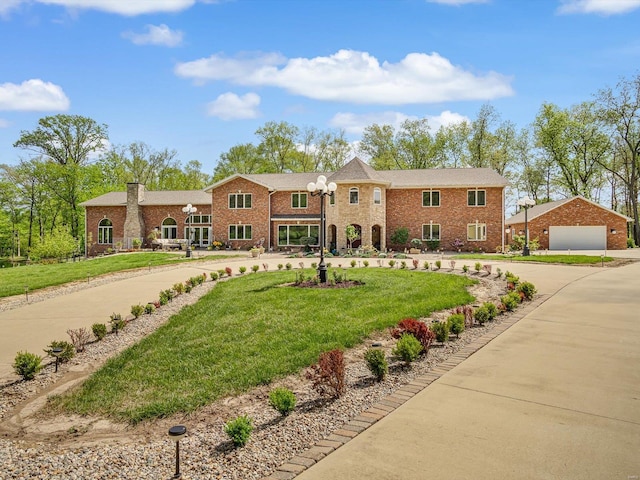 view of front of property with a garage, an outbuilding, and a front lawn