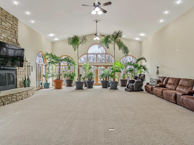 carpeted living room featuring high vaulted ceiling, a fireplace, and ceiling fan