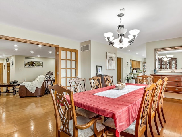 dining room with light hardwood / wood-style flooring and a chandelier