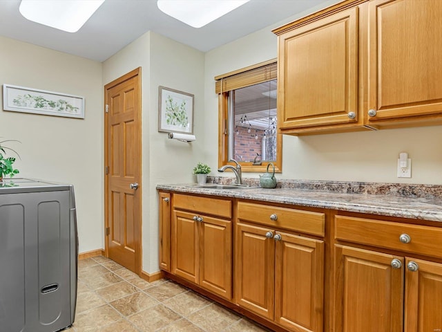 laundry area featuring cabinets, washer / dryer, and sink