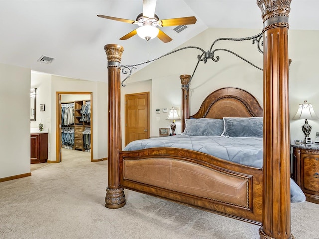 carpeted bedroom with ceiling fan, decorative columns, a spacious closet, vaulted ceiling, and a closet