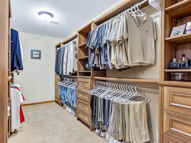 walk in closet featuring light carpet