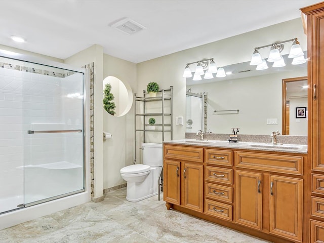 bathroom with vanity, toilet, and a shower with door