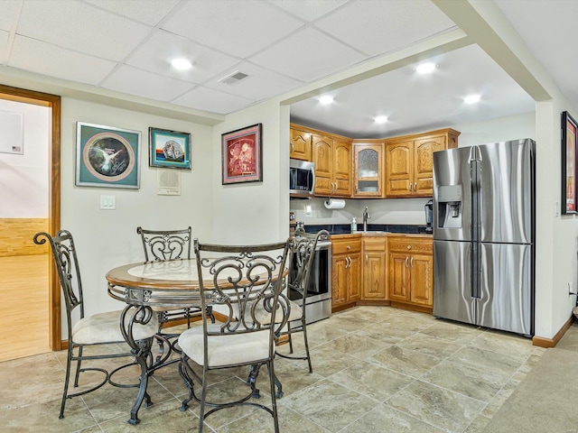 kitchen with a paneled ceiling, appliances with stainless steel finishes, and sink