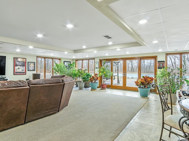 living room featuring french doors, a paneled ceiling, and light carpet