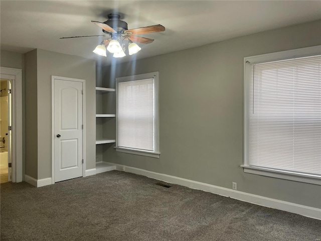 unfurnished bedroom featuring dark colored carpet and ceiling fan