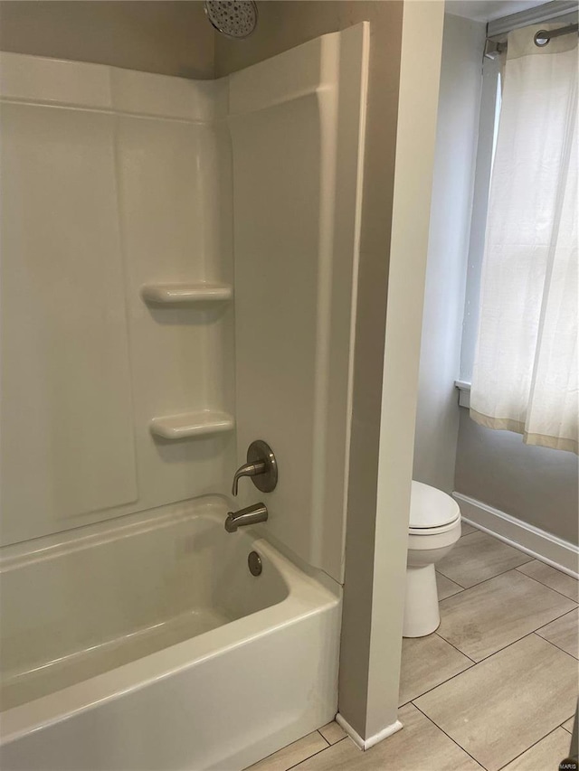 bathroom with toilet, tile patterned floors, and shower / tub combination