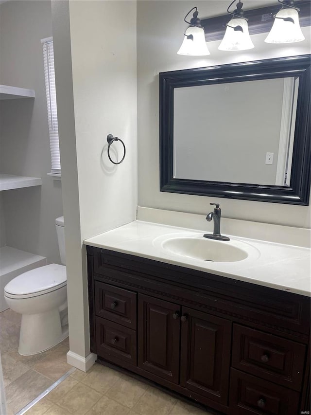 bathroom featuring tile patterned floors, vanity, and toilet