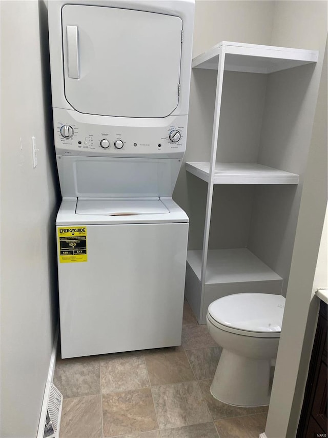 washroom featuring light tile patterned floors and stacked washing maching and dryer