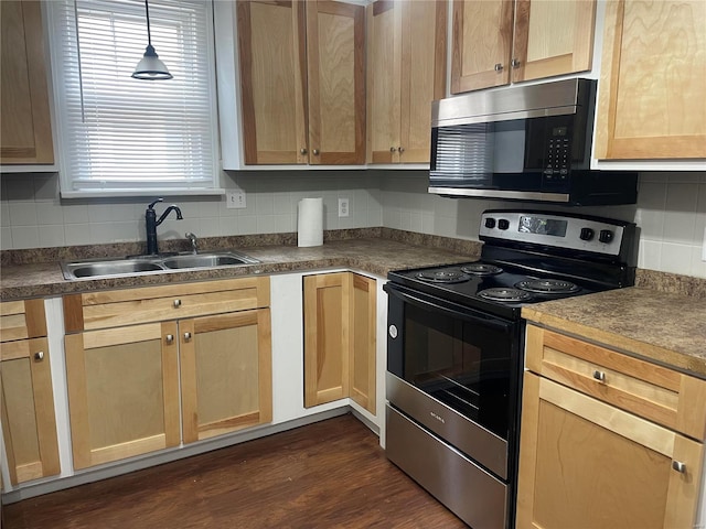 kitchen with appliances with stainless steel finishes, tasteful backsplash, sink, decorative light fixtures, and dark wood-type flooring