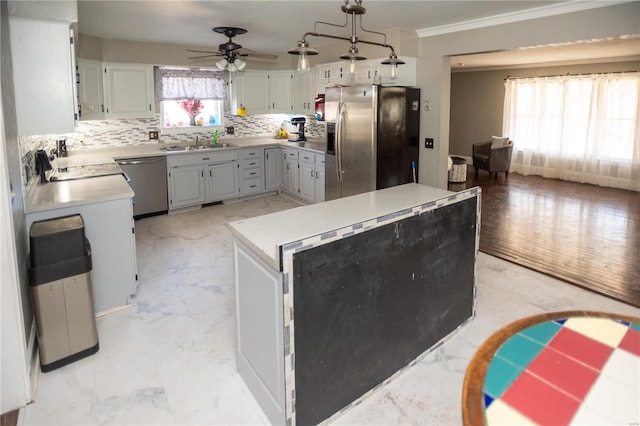 kitchen featuring ceiling fan, crown molding, stainless steel appliances, tasteful backsplash, and light wood-type flooring