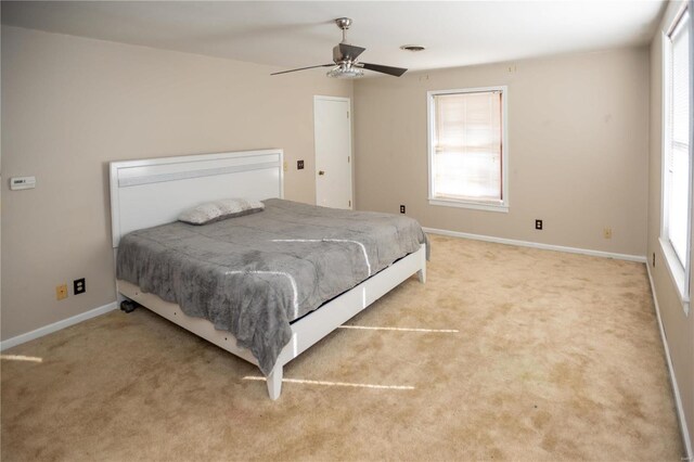 bedroom with ceiling fan and light carpet