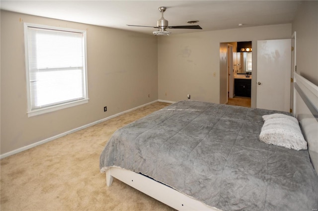 carpeted bedroom with ceiling fan and connected bathroom