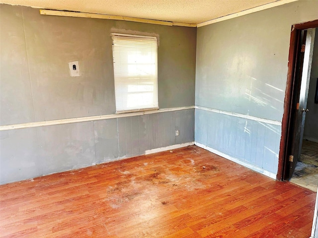 empty room with a textured ceiling and wood-type flooring