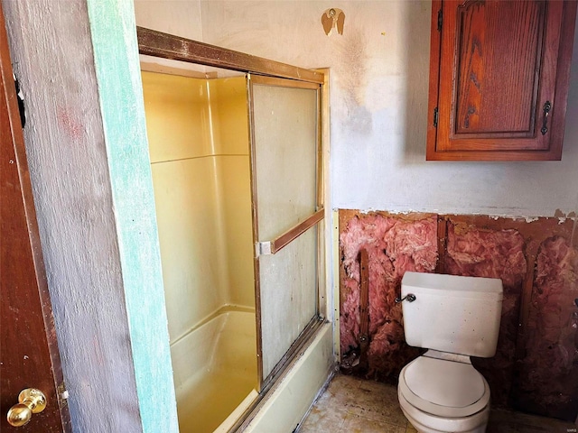 bathroom with tile floors, enclosed tub / shower combo, and toilet