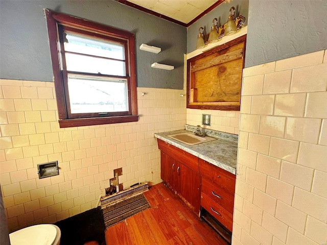 bathroom featuring tile walls, toilet, vanity, and hardwood / wood-style flooring