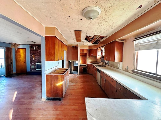 kitchen featuring dark wood-type flooring, brick wall, a wealth of natural light, and sink