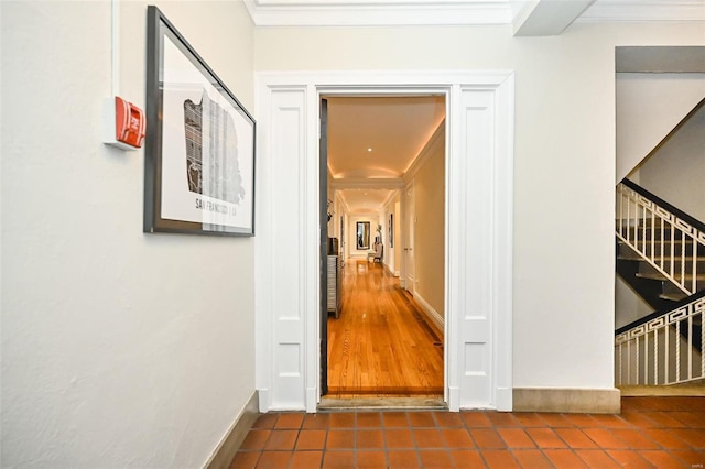 corridor featuring dark tile patterned floors and ornamental molding