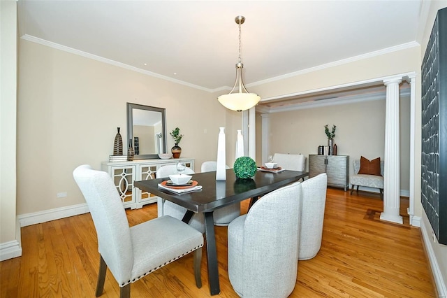 dining area with light wood-type flooring, crown molding, and decorative columns