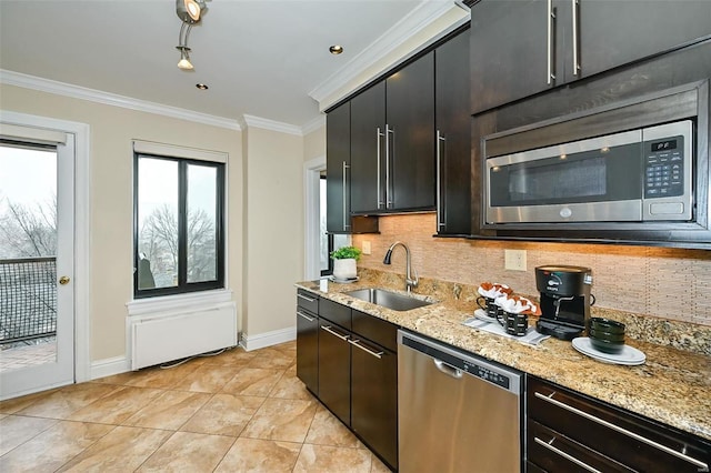 kitchen with sink, stainless steel appliances, light stone counters, backsplash, and ornamental molding