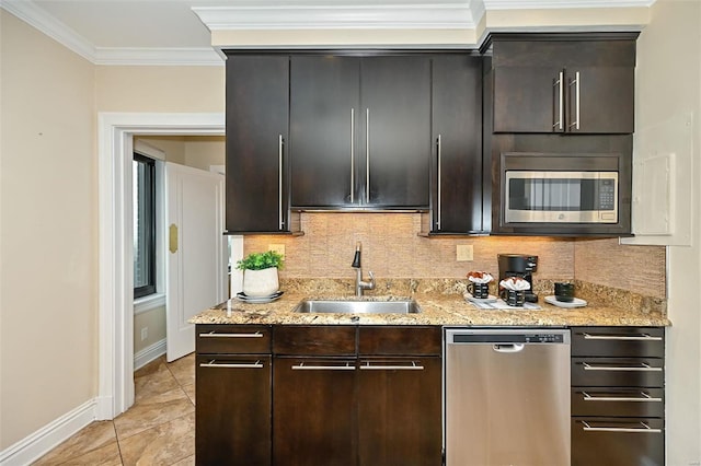 kitchen featuring light stone countertops, sink, appliances with stainless steel finishes, and ornamental molding