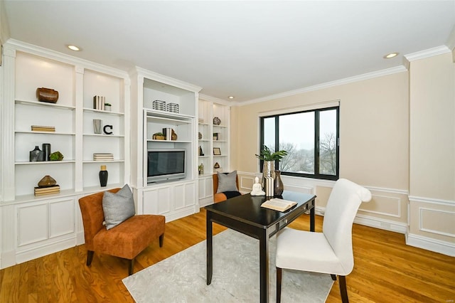 office space featuring built in shelves, ornamental molding, and light wood-type flooring