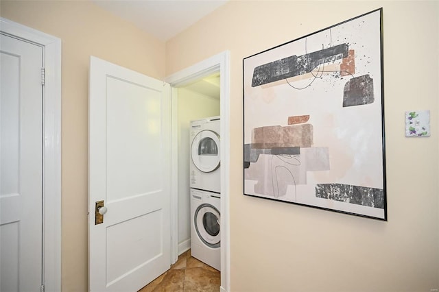 laundry area featuring light tile patterned floors and stacked washing maching and dryer