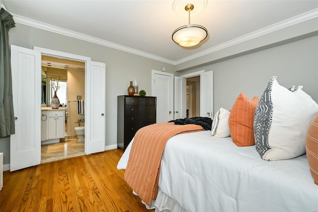 bedroom with connected bathroom, light hardwood / wood-style flooring, and ornamental molding