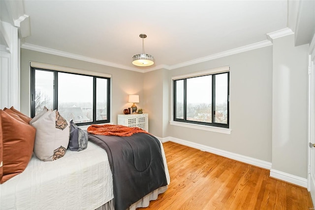 bedroom with light wood-type flooring, crown molding, and multiple windows