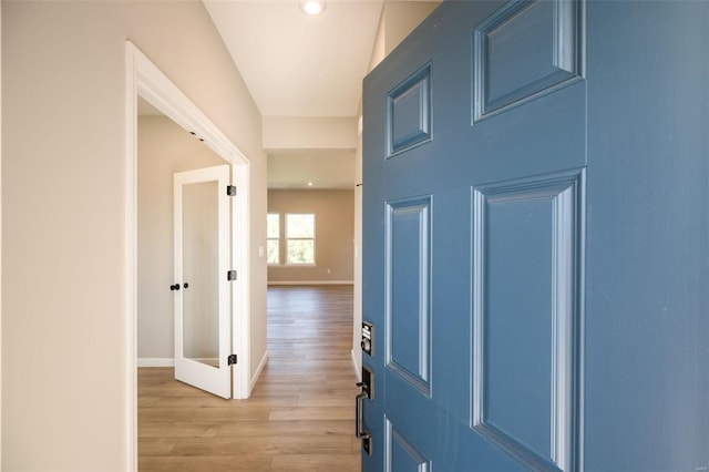 hall with light wood finished floors and baseboards