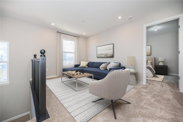 living area with recessed lighting, baseboards, and light colored carpet