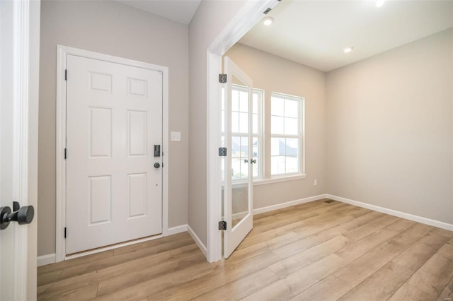 foyer entrance with light wood-type flooring and baseboards