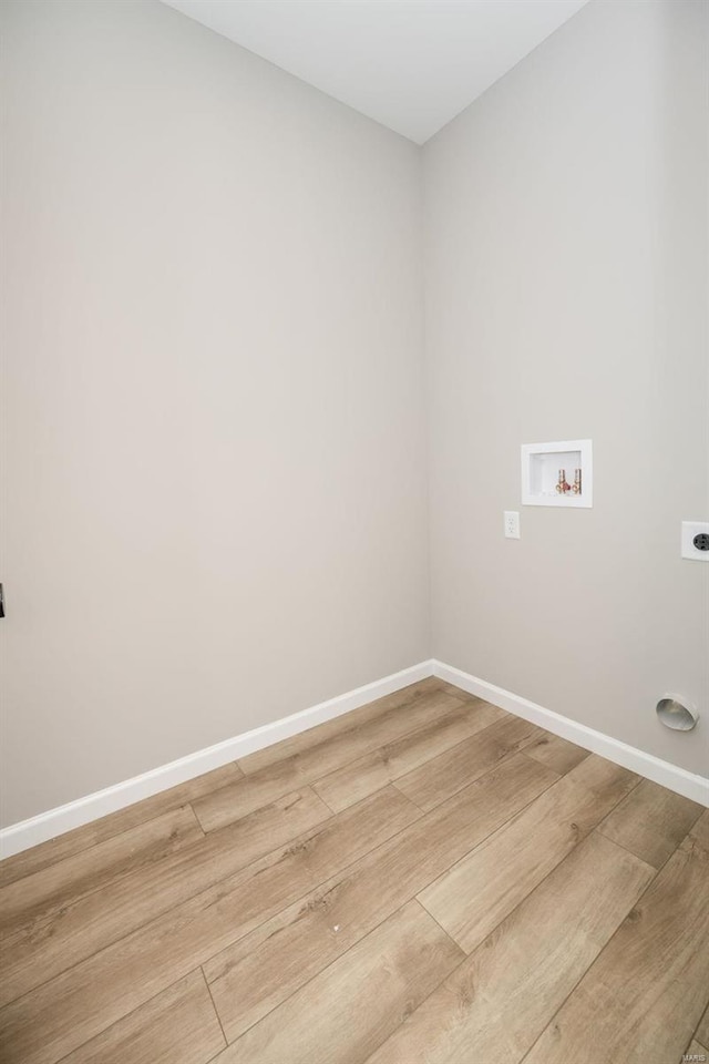 clothes washing area with washer hookup, hookup for an electric dryer, wood finished floors, laundry area, and baseboards