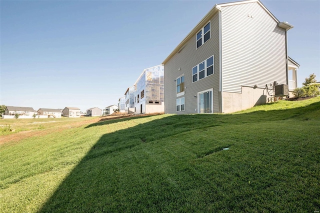 back of property with central AC unit and a lawn