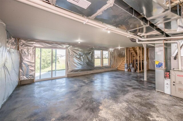 unfinished basement featuring visible vents and a healthy amount of sunlight