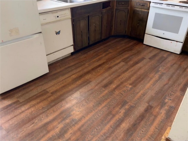 kitchen with dark hardwood / wood-style flooring, white appliances, and dark brown cabinetry